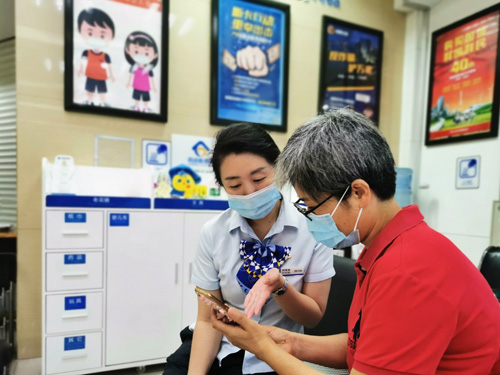 建行成都第六支行，大堂經(jīng)理為客戶介紹手機(jī)銀行“大字”模式